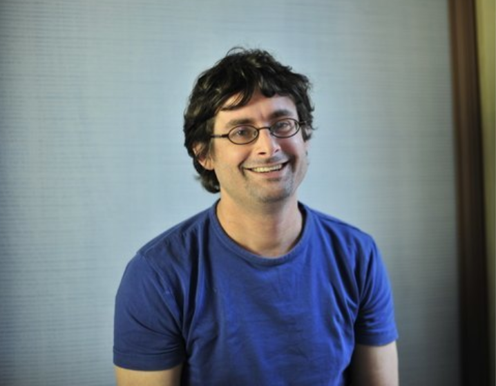 Fotografía casual de Pieter Wuille. El desarrollador aparece sonriendo en un fondo gris.