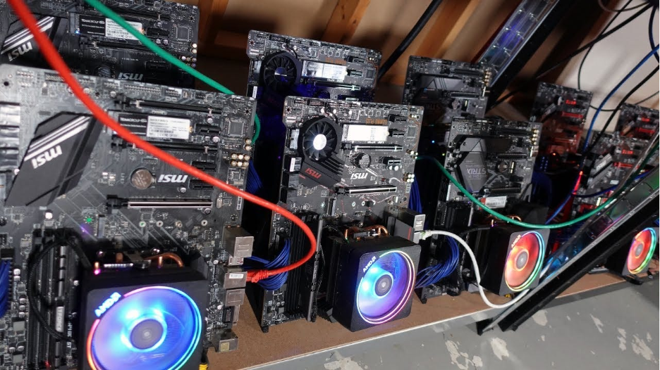Varias placas base alineadas en una estructura abierta, cada una equipada con un procesador (CPU) con disipador y ventilador RGB, conectadas mediante cables de alimentación y red, utilizadas para minería de criptomonedas.