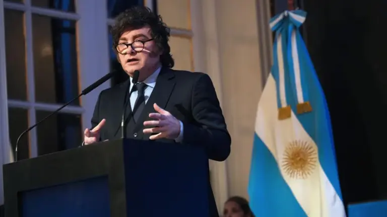 Javier Milei hablando en un atril con la bandera argentina detràs. Imagen de archivo.