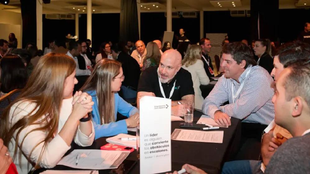 Un grupo de hombres y mujeres conversando alrededor de una mesa