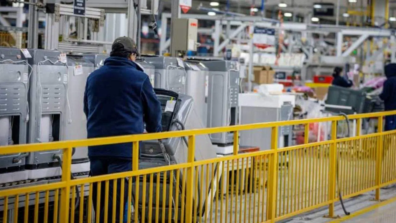 Un obrero de una fábrica de electrodoméstico camina entre los productos
